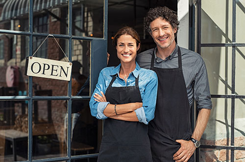 Business owners standing outside of their store